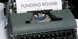 Typewriter with a sheet of paper and the words 'funding round'