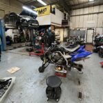 Photo of garage with cars and motorcycles being repaired