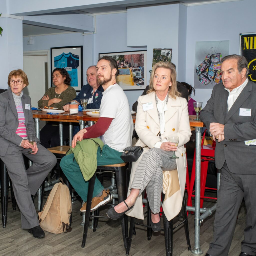 Guests at Community Advocate reception, including Mike and Julie Clare, listening to the speeches